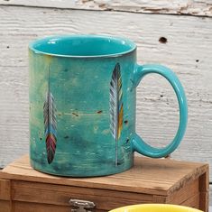 a coffee mug with two feathers painted on it