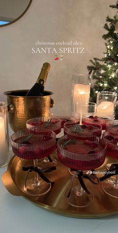 there are many glasses on the tray with wine in them and candles next to it