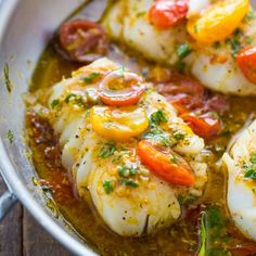 some kind of food that is in a pan on a wooden table and ready to be eaten