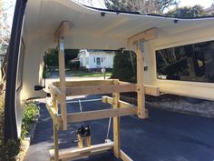 an rv is parked in front of a house with a white awning over it