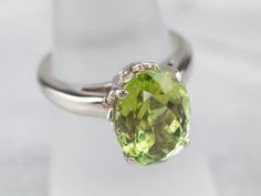 This classically designed green tourmaline solitaire ring is timeless and goes with everything! This simple and elegant ring features a polished white gold mounting. The green tourmaline is a rich lime green, beautifully protected in the simple four-prong setting.Metal: 14K White GoldGem: Green Tourmaline 5.38 CaratsGem Measurements: 12.8 x 9.4 mm, OvalRing Size: 6.50Marks: “SGI 14K” Stamped on the inside band Classic Peridot Solitaire Jewelry, Classic Solitaire Peridot Jewelry, Timeless Green Solitaire Ring, Classic Peridot Green Rings, Classic Green Peridot Ring, Classic Solitaire Peridot Ring, Elegant Peridot Solitaire Ring, Elegant Solitaire Peridot Ring, Classic Peridot Ring For Formal Occasions