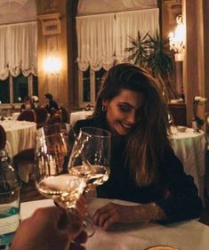 two people sitting at a table with wine glasses