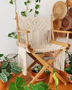 a wooden chair sitting next to some potted plants