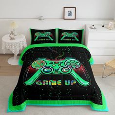 a bed covered in a black and green comforter with two video game controllers on it