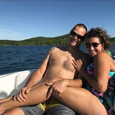 a man and woman sitting on the back of a boat