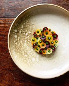 a white bowl filled with food on top of a wooden table