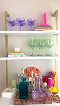 the shelves are filled with bottles, glasses and other decorative items on it's sides