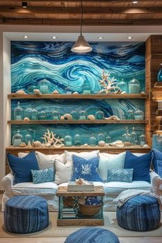 a living room filled with lots of furniture and walls covered in ocean themed wallpaper