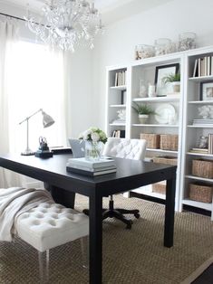 a black table with white chairs and a chandelier