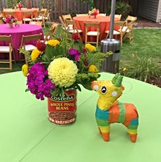 a vase filled with flowers sitting on top of a table next to a toy horse