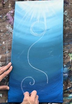 someone is working on an acrylic painting that looks like a question mark in the sky