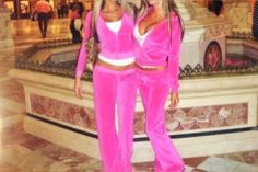 two women in pink outfits standing next to each other on a marble floored area