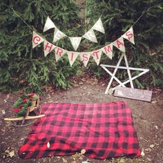 a red and black blanket sitting on top of a tarp next to a christmas tree