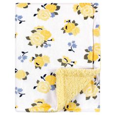 a blanket with yellow flowers on it, and a white sheet that has been folded over