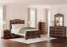 a bedroom scene with focus on the bed and dressers in the foreground, along with hardwood flooring