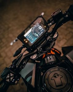 a close up of a motorcycle with a cell phone on the handlebars