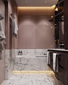 a bathroom with marble flooring and walls, along with white towels hanging on the wall