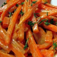 some carrots are piled on top of each other and garnished with parsley