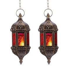 two metal lanterns hanging from chains with red lights on them, one is lit and the other has a flame in it