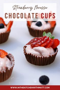 strawberry mousse chocolate cups with whipped cream and strawberries in the middle on a white plate