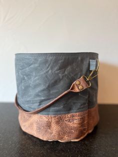 Use this project bag to hold yarn and extras, big enough for the yarn quantity of a sweater! Interior pockets all the way around inside the bag to hold notions & pattern. Bison leather bucket handle is paired with gorgeous 11.5oz tightly woven waxed canvas exterior and organic cotton interior.  The waxed canvas is pliable yet holds its own shape to stand alone. Waxed canvas crinkles as it is used, creating a unique rustic worn-soft look. Bison leather handles are rustic leather, no edge treatmen Waxed Canvas Backpack, Yarn Holder, Bison Leather, Sweater Bags, Yarn Cake, Craft Bags, Project Bag, Yarn Projects, Buffalo Leather