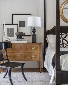 a bed room with a neatly made bed next to a night stand and a chair