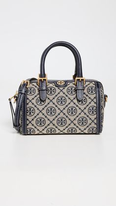 Find TORY BURCH T Monogram Jacquard Barrel Bag on Editorialist. This Tory Burch barrel bag is crafted from jacquard fabric with leather trim. It features a monogram pattern, gold-toned hardware, a structured base with metal feet, and a zip at the top. The bag has an interior patch pocket and an optional, adjustable strap. The lining is made of suede. It measures 4.75 inches in height, 7.5 inches in length, and 4.25 inches in depth. The strap drop is 21.75 inches and the handle drop is 2.25 inche T Monogram, Navy Blue Print, Aesthetic Bags, Drawing Bag, Barrel Bag, Monogram Pattern, Tory Burch Bag, Jacquard Fabric, Louis Vuitton Speedy Bag