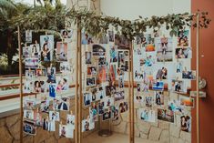 a room divider with pictures and greenery on the top, along with photos hanging from it