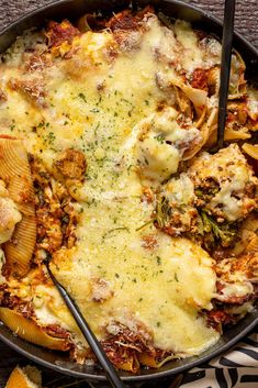 a skillet filled with pasta and meat covered in cheese