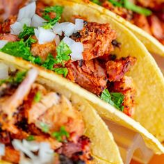 three tacos filled with meat, onions and cilantro