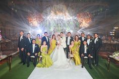 a group of people posing for a photo in front of a stage with chandeliers