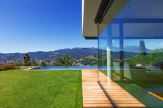 the view from inside a modern home overlooking a lake and mountains in the distance,