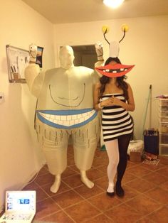 a woman standing next to a giant inflatable character