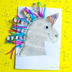 a unicorn made out of newspaper strips on a yellow background with confetti sprinkles