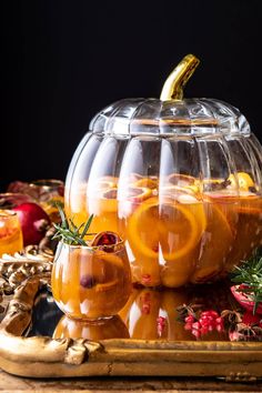 a glass bowl filled with orange slices and garnish on top of a wooden table