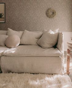 a white couch with pillows on it in a living room