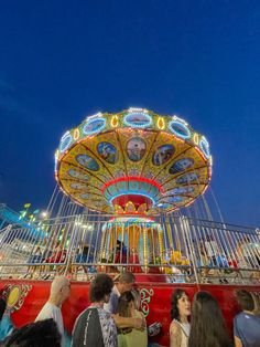 people are standing in front of a merry go round