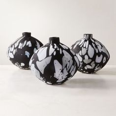 three black and white vases sitting next to each other