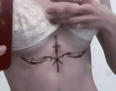 a woman with a cross tattoo on her stomach