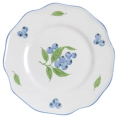 a white plate with blue flowers and green leaves