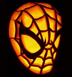 a pumpkin carved to look like a spider - man's web on its face