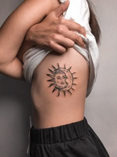 a woman with a sun tattoo on her stomach and the moon behind her back shoulder