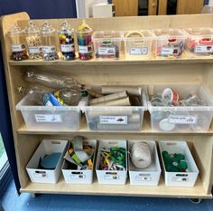 a shelf filled with lots of craft supplies on top of a blue carpeted floor