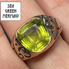 "Welcome to Sea Green Mermaid! For sale is a 10k yellow gold peridot ring. This antique ring is splendid! The natural peridot has a wonderful and unusual trapezoid shape with beautiful facets. The peridot has the classic luminous lime green glow, with lovely translucence. This large gemstone is securely bezel-set. The signet style ring is deeply carved with scrolling designs. This bewitching ring will energize and enchant you whenever you chose to wear it! The item shows normal wear for a pre-ow Green Citrine Rings With Accent Stones, Green Citrine Gemstone Rings, Oval Green Citrine Rings, Green Citrine Jewelry For Anniversary, Anniversary Green Signet Ring With Bezel Setting, Vintage Peridot Ring For May Birthstone, Yellow Peridot Jewelry For May Birthstone, Yellow May Birthstone Jewelry, Green Jewelry With Accent Stones For Collectors