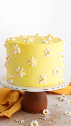 a yellow cake with white flowers on it