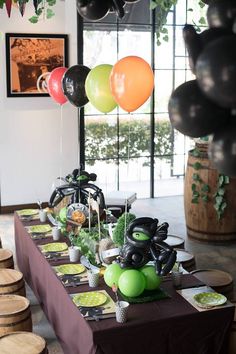 the table is set up with balloons and plates