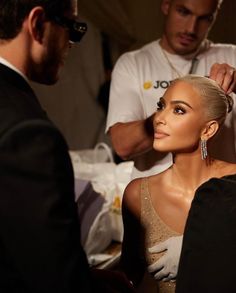 a woman getting her hair styled by a man