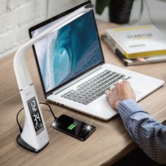 a man is working on his laptop with an external charger attached to the dock