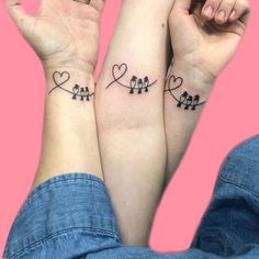 two people holding hands with tattoos on their arms, one has birds and the other has hearts