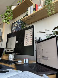 two computer monitors sitting on top of a wooden desk